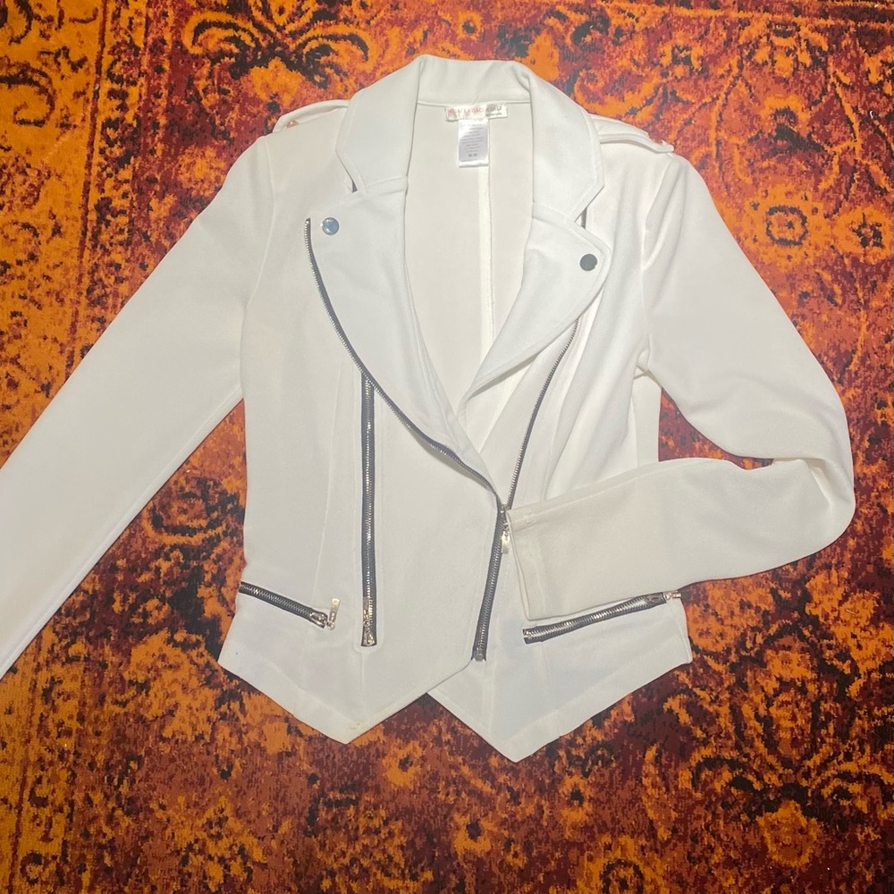 White jacket with black and gold zippers and buttons